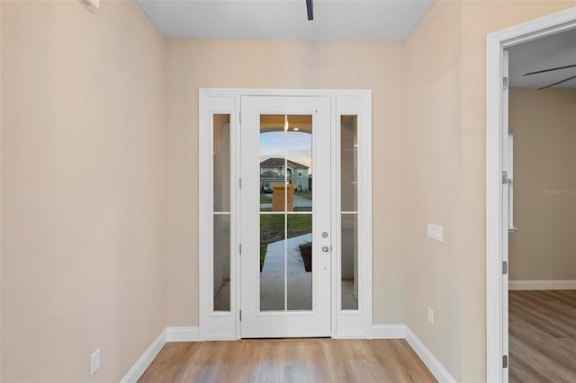 doorway with light wood-style flooring and baseboards