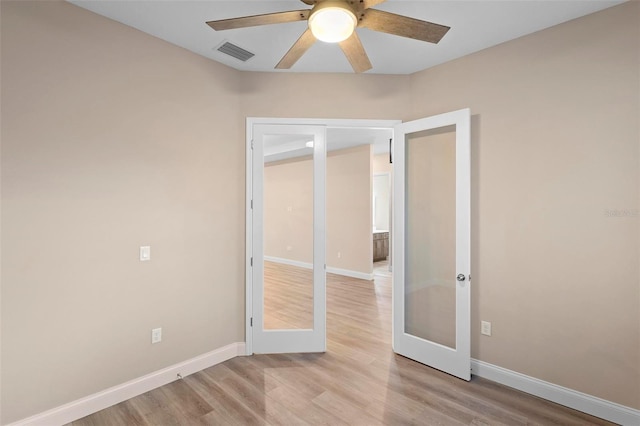 empty room with a ceiling fan, baseboards, visible vents, light wood-style floors, and french doors