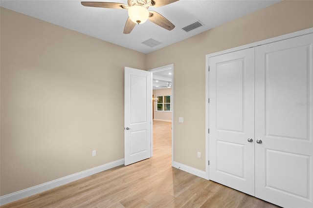 unfurnished bedroom featuring baseboards, visible vents, a ceiling fan, light wood-style flooring, and a closet