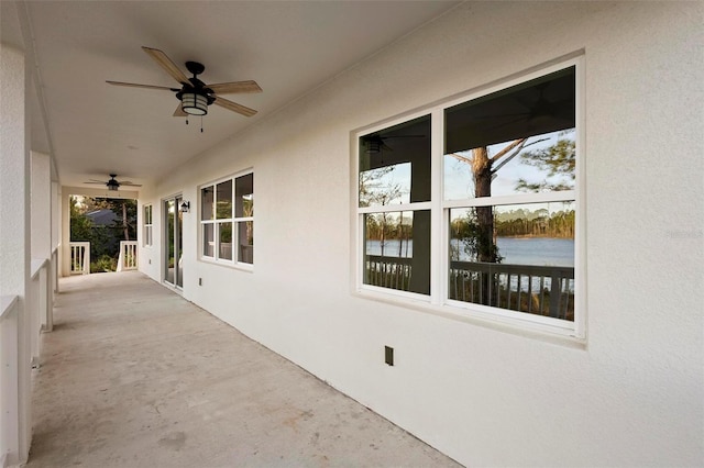 view of patio featuring a water view and ceiling fan