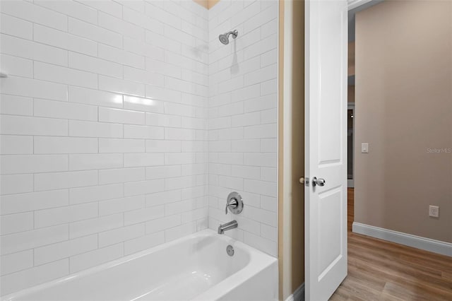 full bath featuring wood finished floors, shower / tub combination, and baseboards