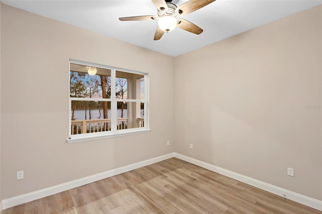 empty room with light wood finished floors, baseboards, and a ceiling fan