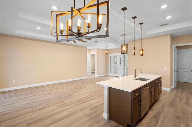 kitchen with pendant lighting, visible vents, stainless steel dishwasher, open floor plan, and a sink