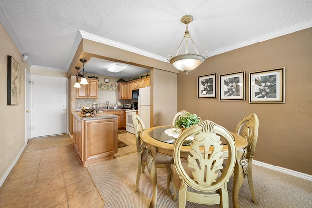 tiled dining room with sink, crown molding, and a textured ceiling