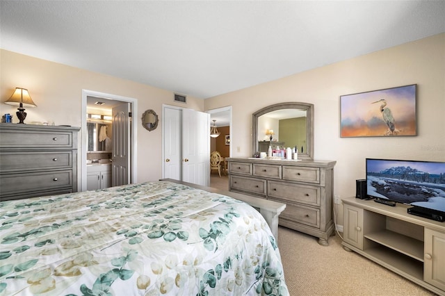 bedroom featuring light colored carpet and ensuite bathroom