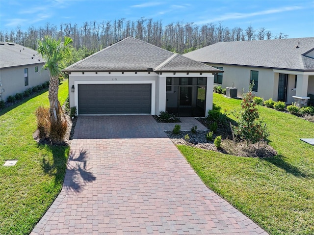 ranch-style house featuring a garage, central AC, a front lawn, and a sunroom