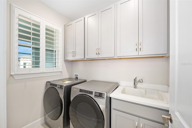 washroom with sink, washer and clothes dryer, and cabinets