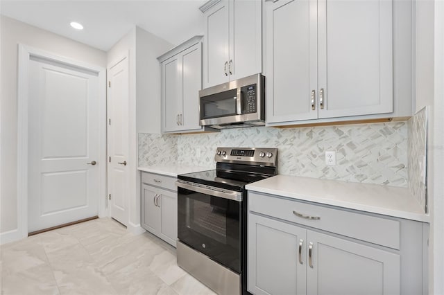 kitchen featuring gray cabinetry, backsplash, and appliances with stainless steel finishes