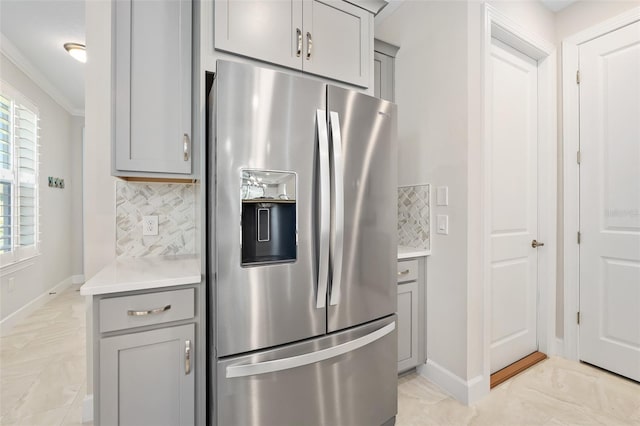 kitchen featuring stainless steel refrigerator with ice dispenser, gray cabinets, and backsplash