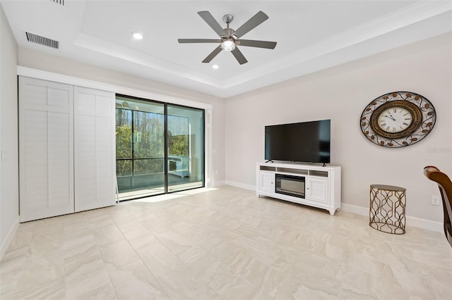 unfurnished living room with ceiling fan and a raised ceiling