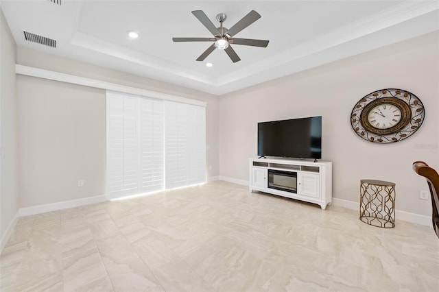 unfurnished living room with ornamental molding, a raised ceiling, and ceiling fan