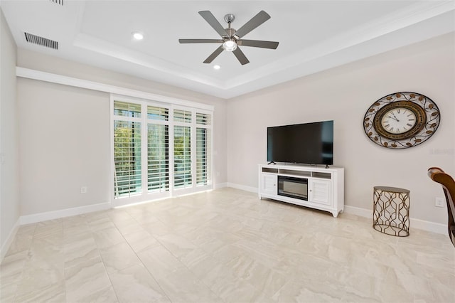 unfurnished living room with ceiling fan and a tray ceiling