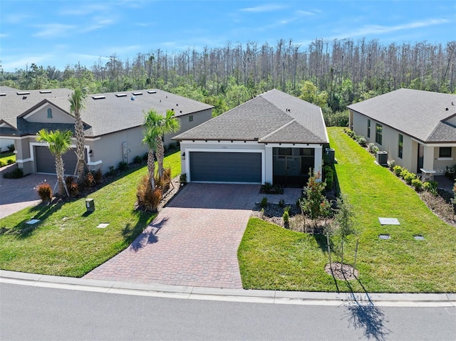 view of front facade featuring cooling unit, a garage, and a front lawn