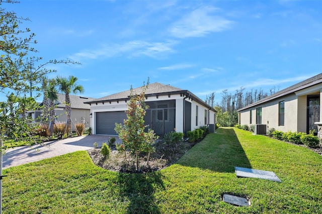 view of side of home with a garage, central AC unit, and a lawn