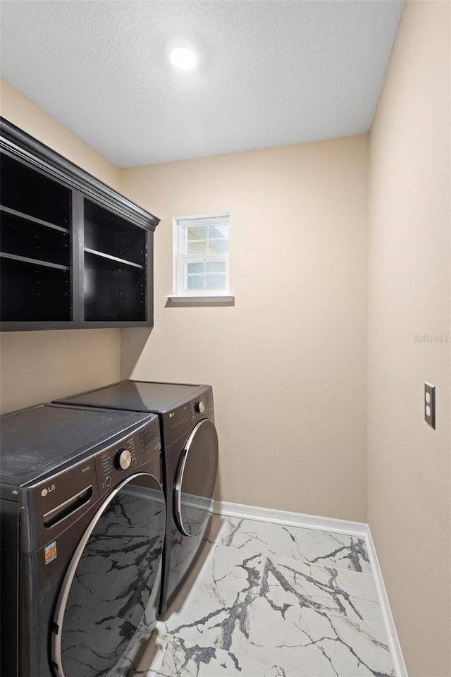 laundry room featuring washer and clothes dryer and a textured ceiling