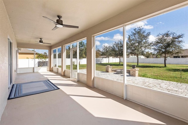 unfurnished sunroom featuring ceiling fan