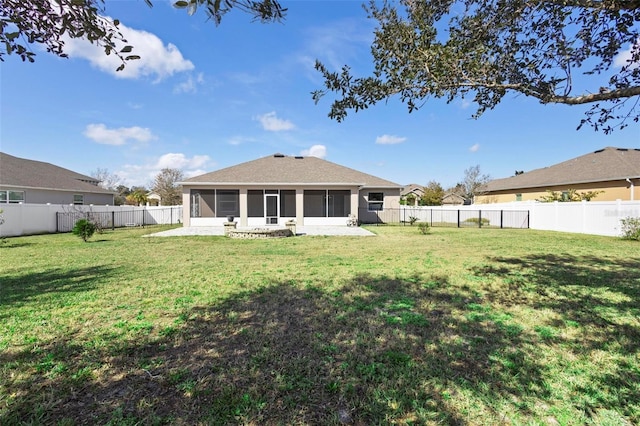 rear view of property featuring a sunroom, a fenced backyard, and a lawn