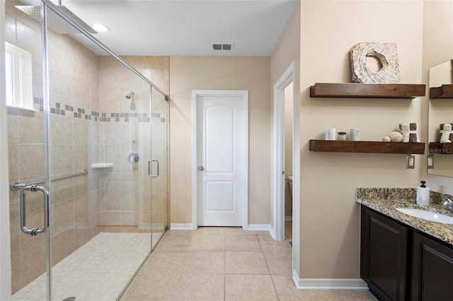 bathroom with a shower stall, baseboards, vanity, and visible vents