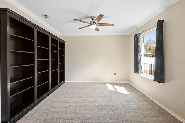 empty room featuring ceiling fan, baseboards, ornamental molding, and carpet