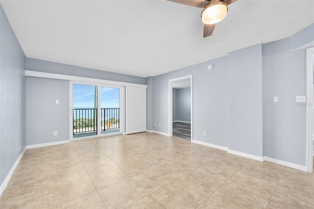 unfurnished room with light tile patterned flooring, ceiling fan, and baseboards