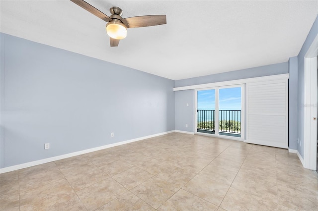 unfurnished room featuring ceiling fan, light tile patterned floors, and baseboards