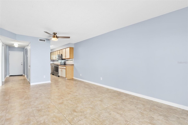 unfurnished living room featuring baseboards, visible vents, and a ceiling fan