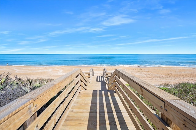 view of community with a water view and a beach view