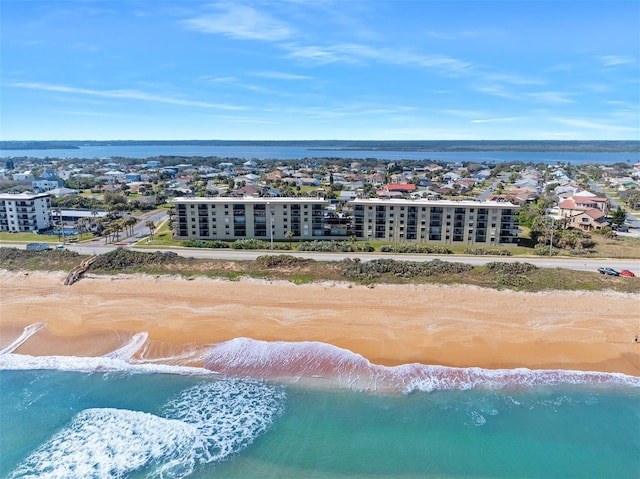 drone / aerial view with a water view, a city view, and a view of the beach