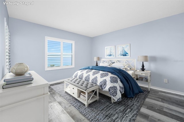 bedroom with baseboards and wood finished floors