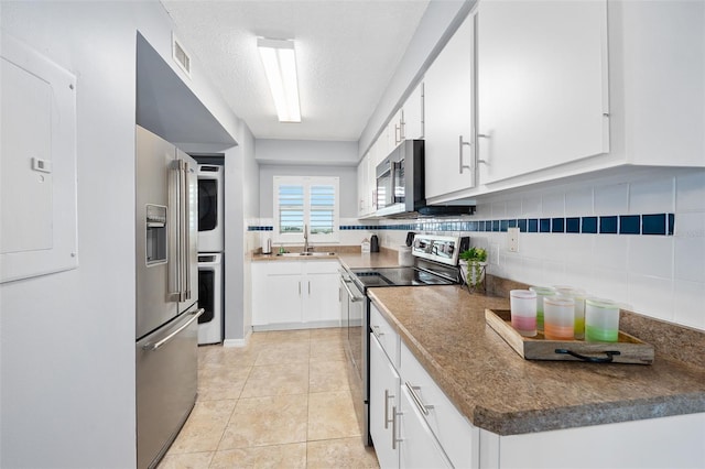 3180 Ocean Shore Blvd Unit 309, Ormond Beach, FL 32176 - kitchen with appliances with stainless steel finishes, a sink, white cabinetry, decorative backsplash, and a textured ceiling