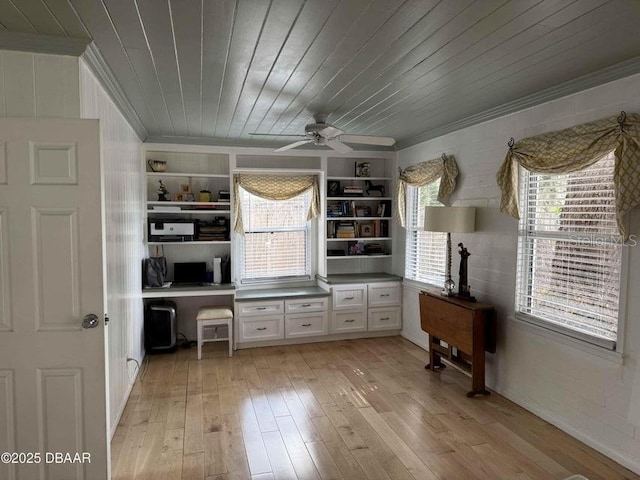 interior space with wood ceiling, ceiling fan, built in desk, ornamental molding, and light hardwood / wood-style floors