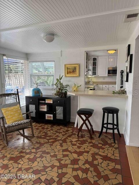 kitchen with a breakfast bar area, kitchen peninsula, and white cabinets