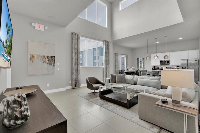 living room featuring light tile patterned flooring and a towering ceiling