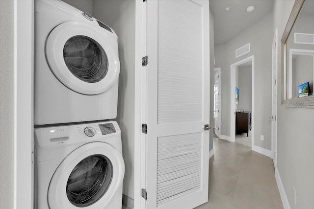 clothes washing area featuring stacked washer / dryer