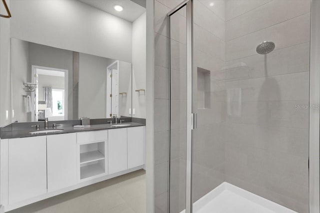 bathroom featuring a shower with door and vanity