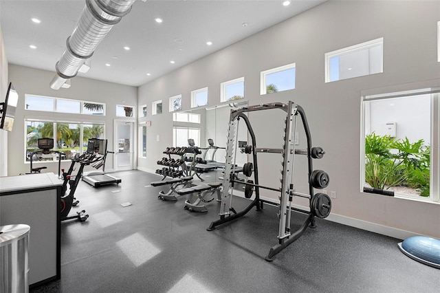 exercise room with a towering ceiling