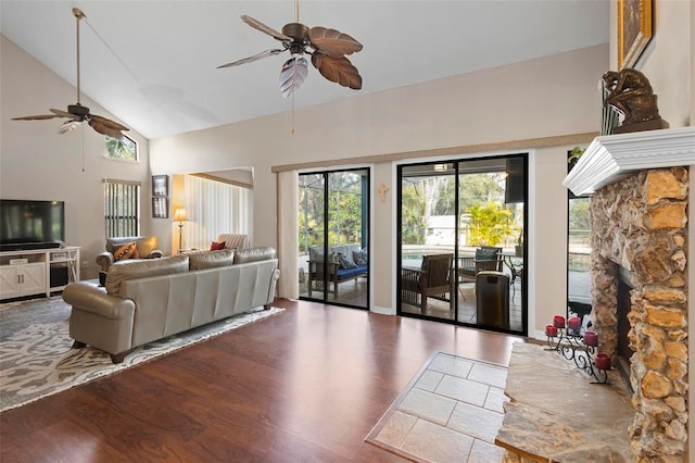 living room with a fireplace, dark wood-type flooring, high vaulted ceiling, and ceiling fan