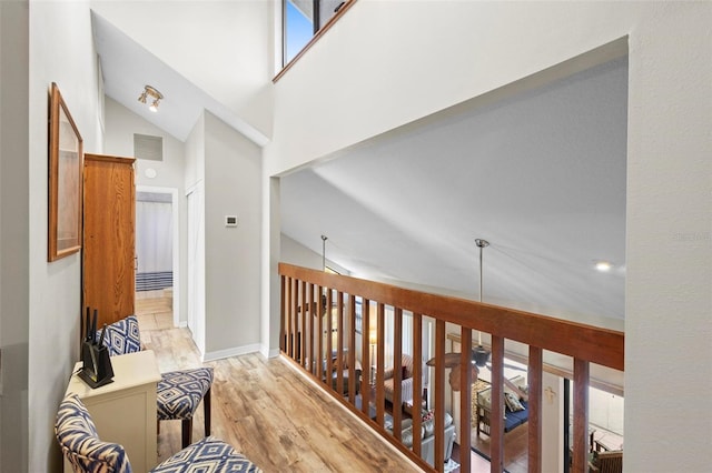 hall featuring high vaulted ceiling and light hardwood / wood-style floors