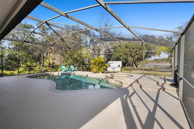 view of swimming pool featuring a patio, a water view, and glass enclosure