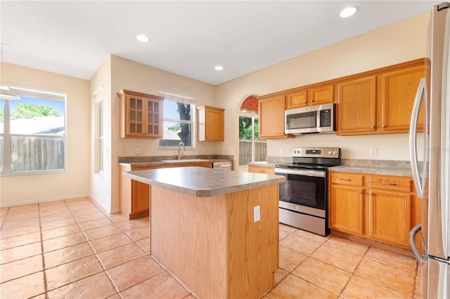 kitchen with a kitchen island, appliances with stainless steel finishes, sink, and a wealth of natural light