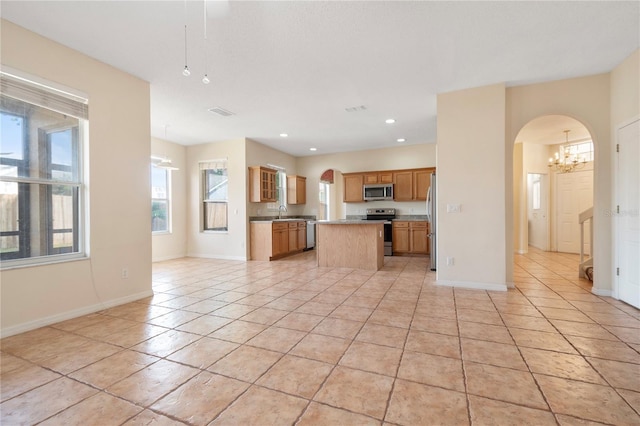 kitchen with light tile patterned floors, stainless steel appliances, and a kitchen island