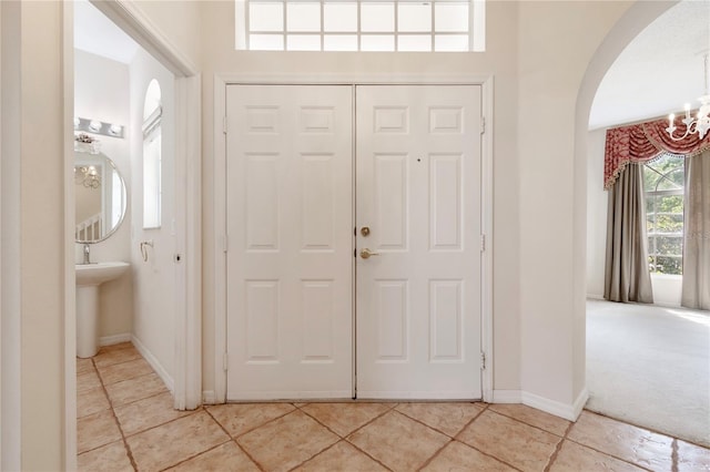 foyer featuring a notable chandelier and light colored carpet