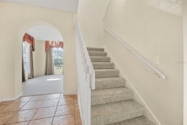 stairway with a notable chandelier