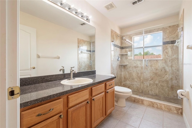 bathroom with tile patterned floors, vanity, toilet, and a shower with shower door