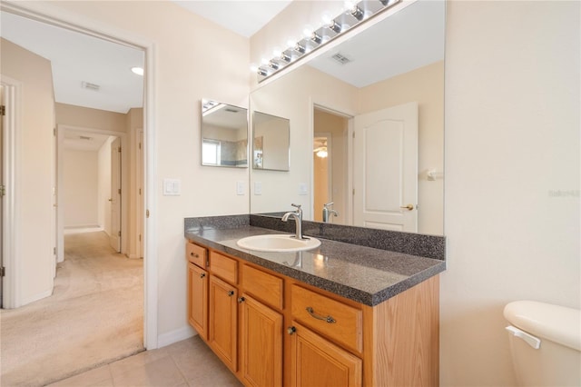 bathroom with vanity, tile patterned floors, and toilet