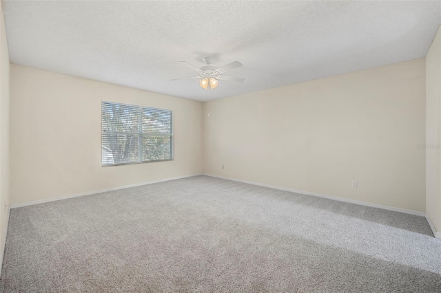 carpeted empty room with ceiling fan and a textured ceiling