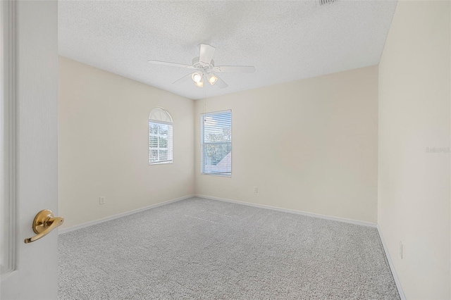 empty room featuring ceiling fan, carpet floors, and a textured ceiling