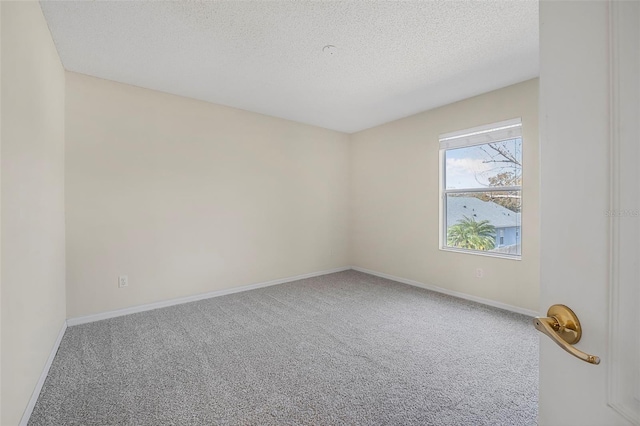 carpeted empty room with a textured ceiling