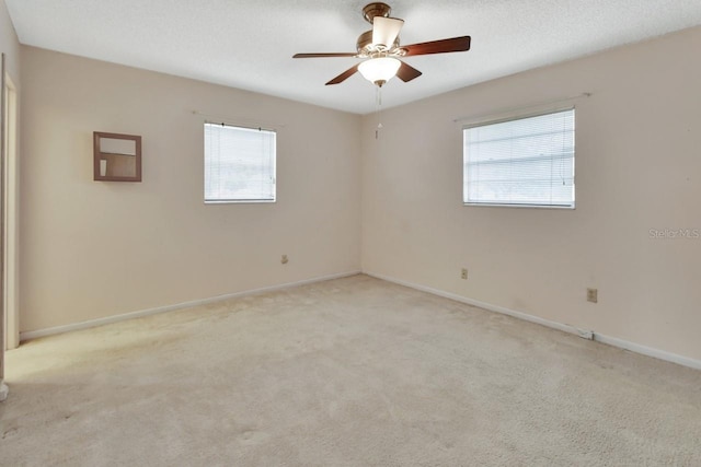 carpeted spare room featuring ceiling fan, a healthy amount of sunlight, and a textured ceiling