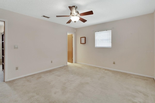 carpeted empty room featuring ceiling fan and a textured ceiling